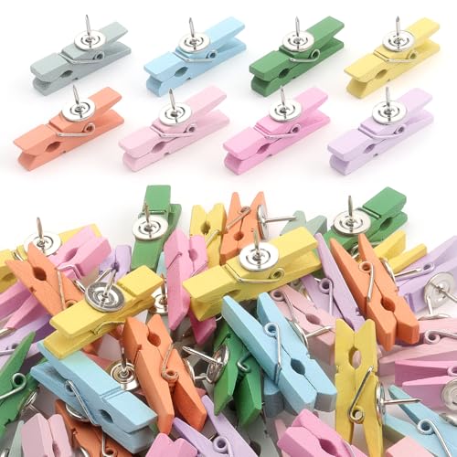 Small wooden clothespin clips in pastel colors with push pins on the back.