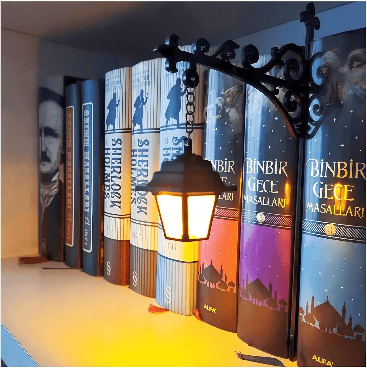 Small hanging lantern on a scrolled bracket clipped to a bookshelf