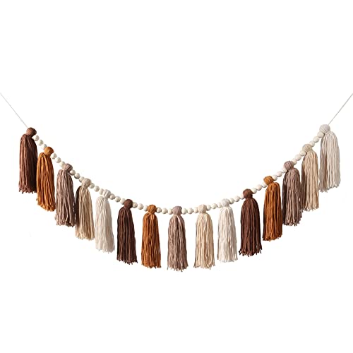 Yarn tassel garland in rust, chocolate and cream tones strung between round wooden beads