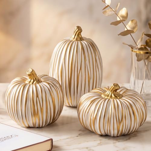 Ribbed cream resin pumpkins with gilded stems arranged on a pale surface