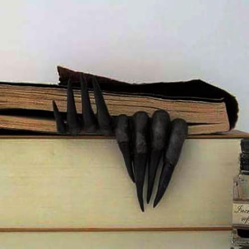 Black clawed hands gripping over the top of a row of books on a shelf