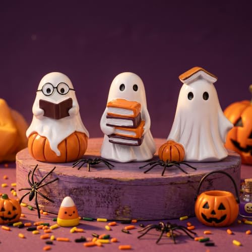 Three small white resin ghost figurines holding open books