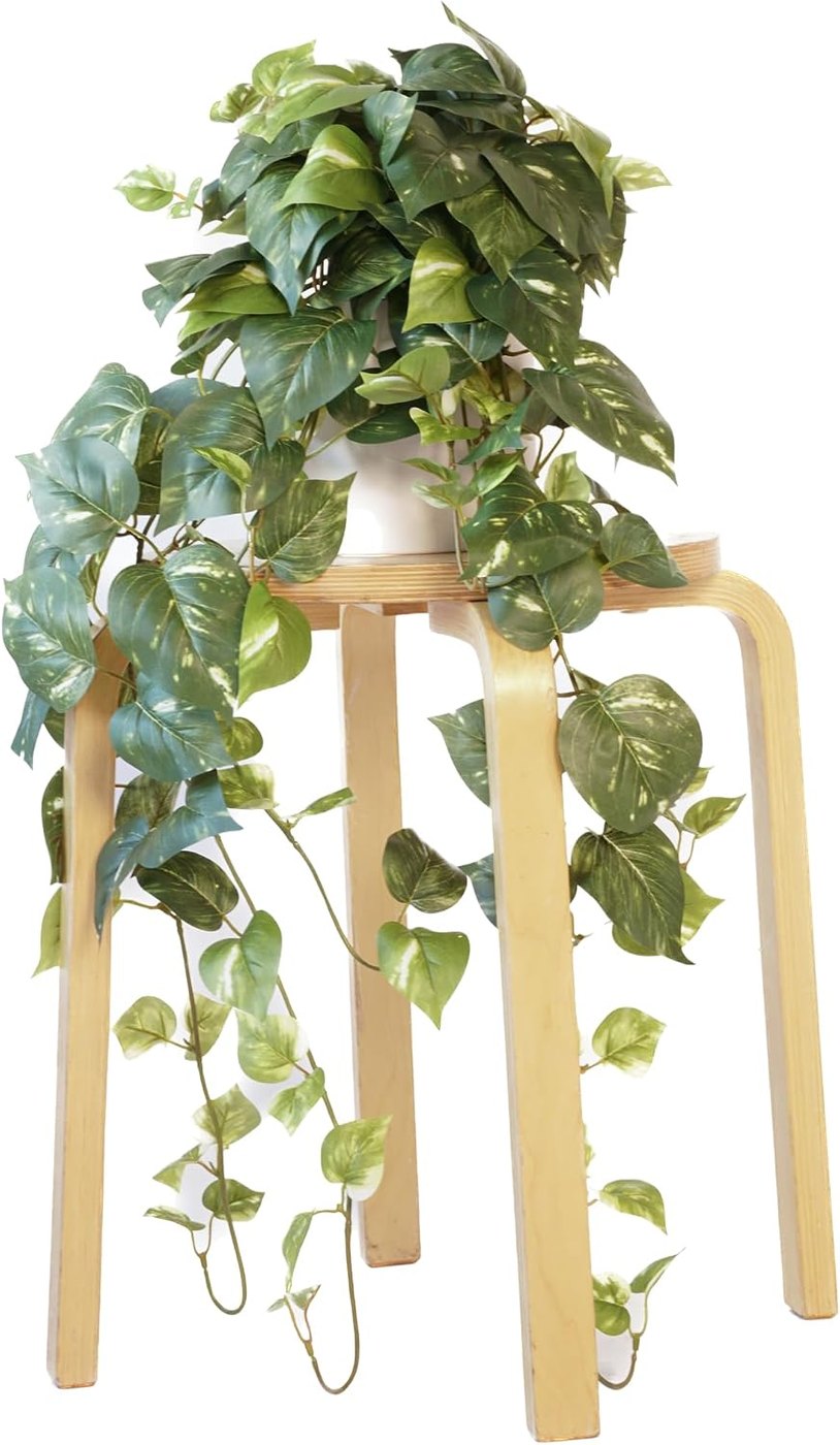 Large variegated artificial pothos plant trailing off a stool