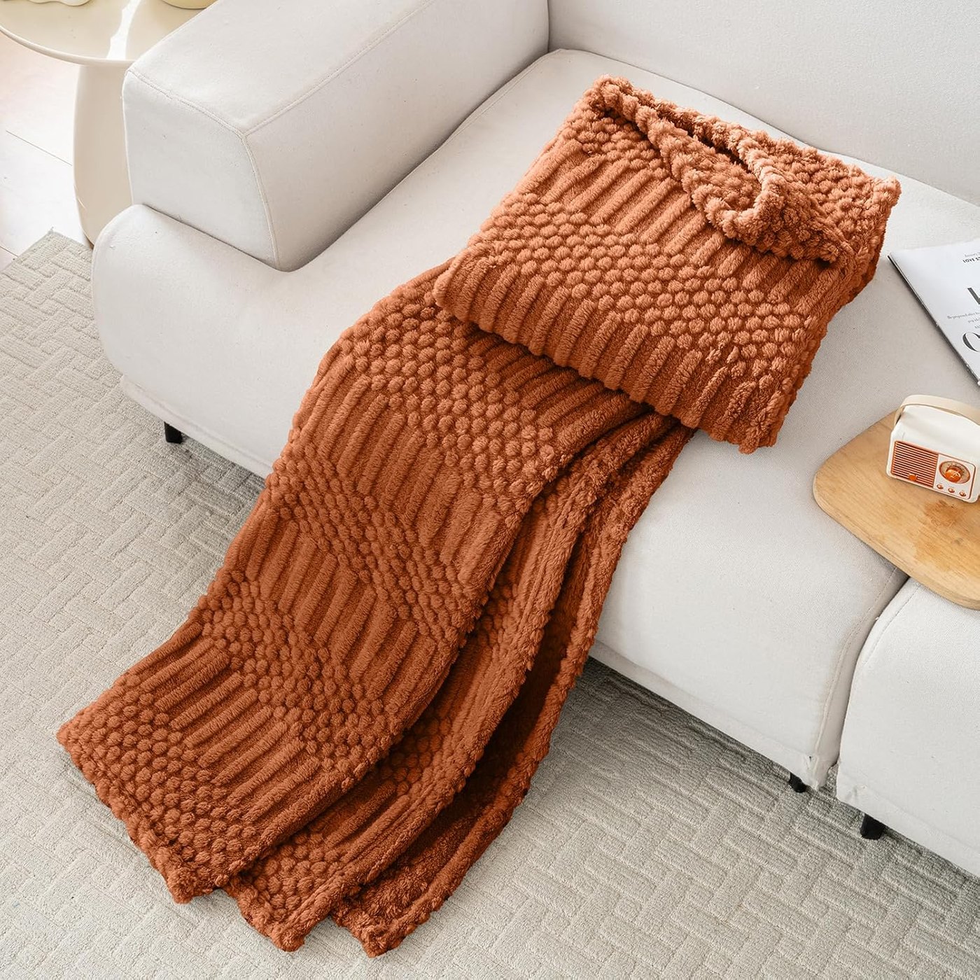 Rust orange textured fleece throw blanket draped over a sofa