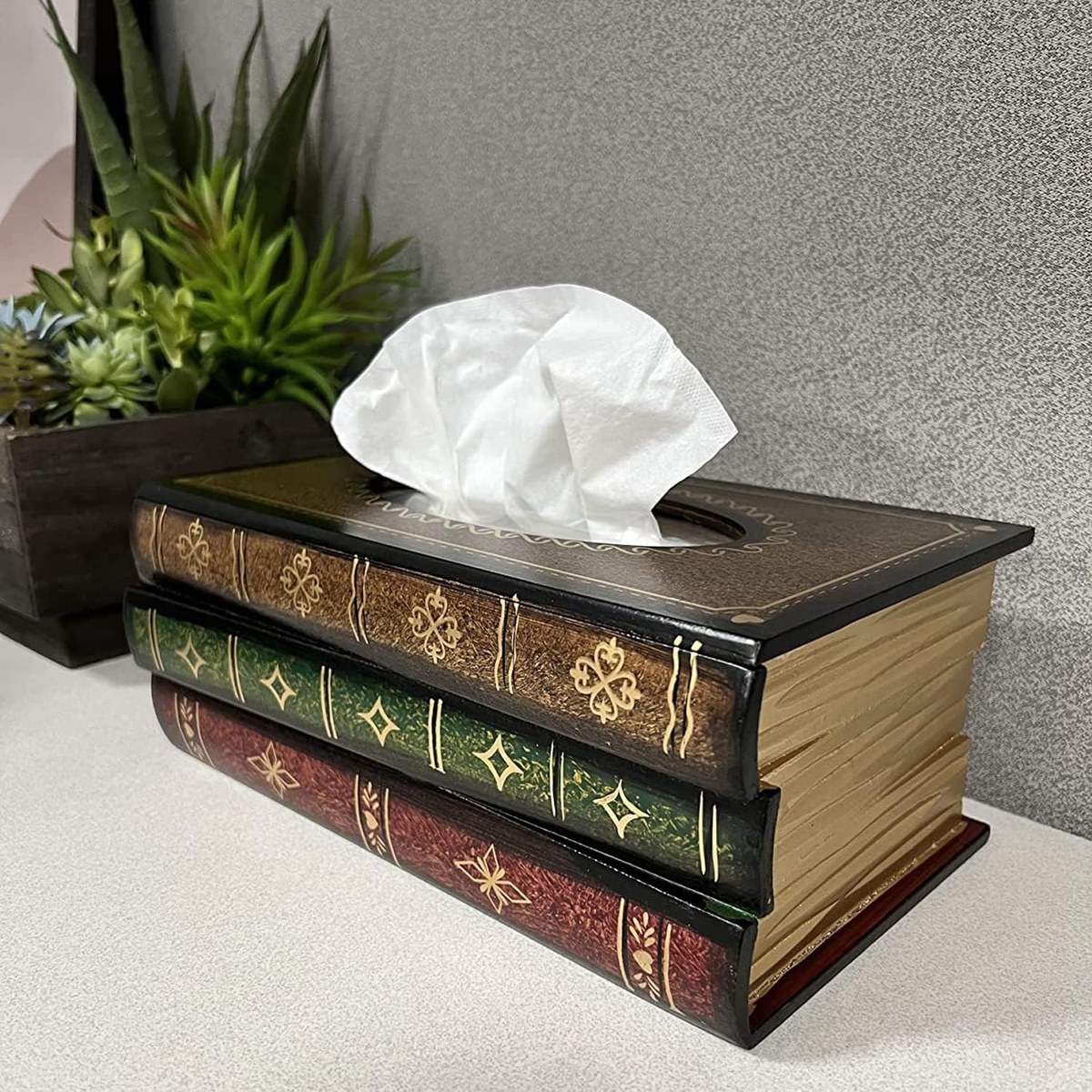 Tissue box cover shaped like three stacked leather bound books with gilt page edges